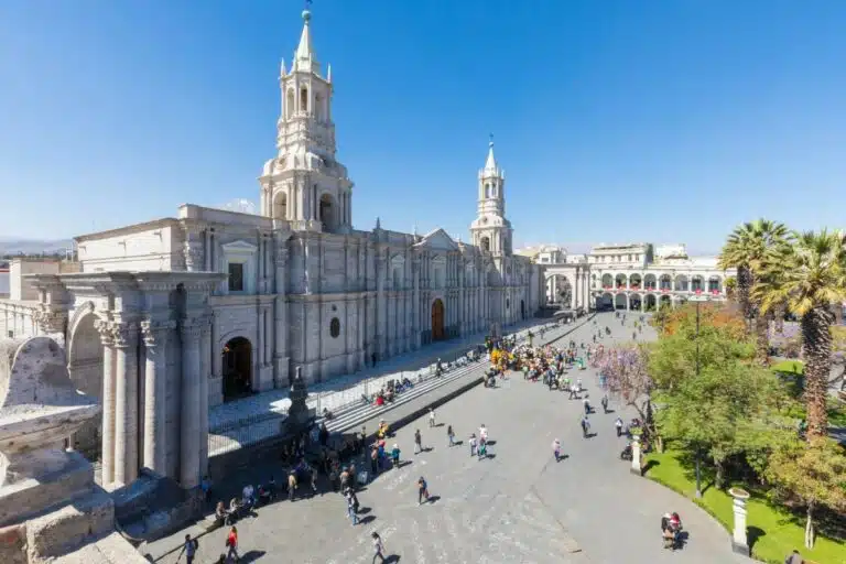 A Large Building With A Tower And People Walking Around